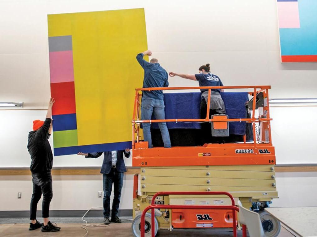 A crew installs the a colorful abstract art work